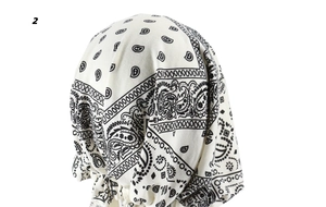Detail of pre-tied turban hat featuring classic black paisley print on white fabric