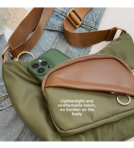 Detail view of large olive green canvas crossbody bag with contrast brown strap and phone