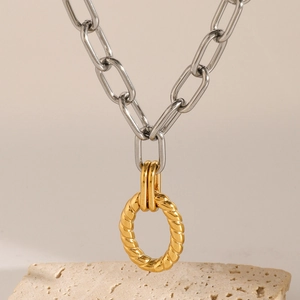 Close-up of a two-tone geometric necklace with a gold twisted rope pendant on a silver chain
