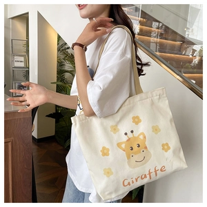 Detailed view of canvas tote bag with giraffe print worn by model in casual indoor setting
