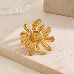 Bague ouverte tournesol en acier inoxydable doré sur un socle en pierre minimaliste