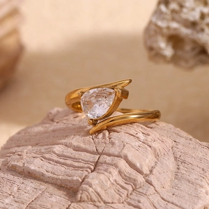 Detailed view of an 18K gold-plated wing ring with teardrop zircon on coral stone