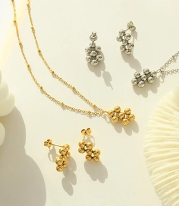 Detail of gold and silver beaded jewelry set featuring a necklace and stud earrings