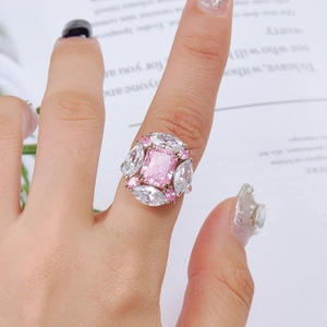Close-up of a luxury silver ring featuring a pink rectangular gemstone with accent diamonds