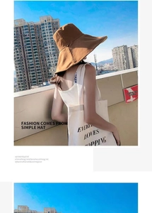 Detail of wide brim brown sun hat showing UV protection coverage in outdoor city setting