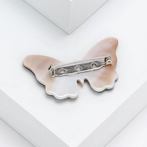 Elegant shell-textured butterfly brooch with marble finish and silver safety pin back