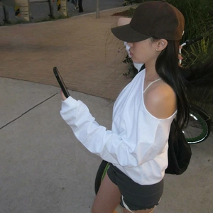 Detail of white off-shoulder long sleeve crop top in casual outdoor street style setting