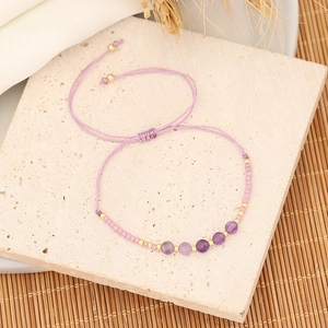 Macro detail of purple woven bead bracelet with natural stones and adjustable pull knot