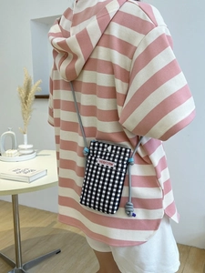 Minimalist black and white checkered crossbody phone bag with a grey knot strap