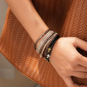 Détail d'un bracelet multi-rangs en cuir avec croix en strass et fermoir magnétique au poignet
