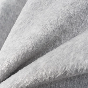 Gros plan sur la texture luxueuse du col en fourrure grise de cette veste