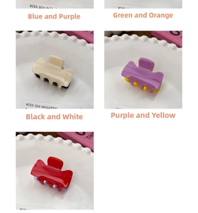 Mini candy-colored hair claws in contrasting color schemes displayed on a ceramic plate