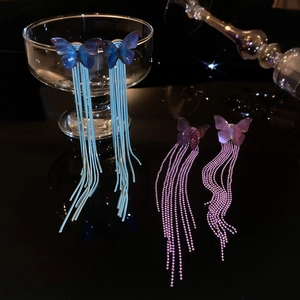 Detail of long butterfly tassel earrings with blue and purple gradient resin wings
