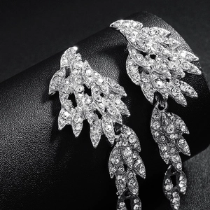 Macro shot of silver leaf drop earrings with sparkling rhinestones for bridal party attire