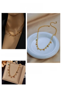 Detail view of gold beaded necklace with vibrant multi-colored round gemstone pendants