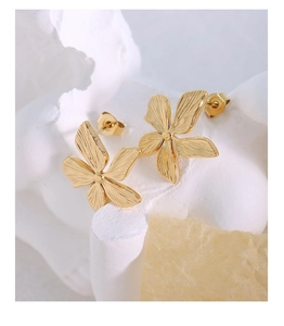 Macro detail of French vintage 18k gold plated flower stud earrings with 3D petal texture