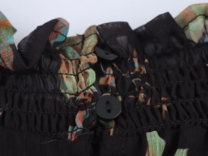Detailansicht der gesmokten Halslinie mit Knöpfen und geblümtem Chiffonstoff