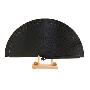 Minimalist black solid wood folding fan on a wooden stand with matte finish design