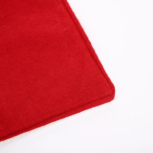Detail of red Christmas placemat with white plush border and embroidery texture
