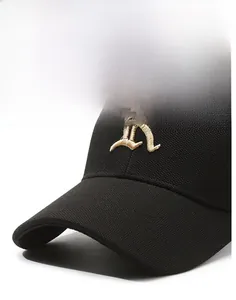 Detail of a black baseball cap featuring a curved brim and golden embroidered letter K