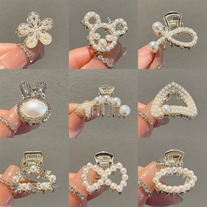 Detail view of 9 mini gold pearl hair claws featuring butterfly and floral designs