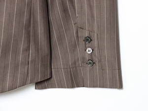 Détail du blazer marron foncé à rayures fines montrant les trois boutons et le tissu sergé