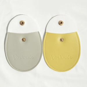 Close-up of PU leather snap-button jewelry pouches in grey and yellow with embossed detail
