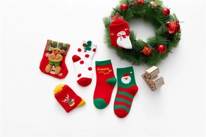 Flat lay of festive Christmas cotton socks with Santa and reindeer motifs in holiday colors