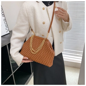 Detail of caramel brown pleated evening bag with gold chain and quilted leather texture