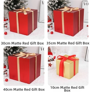 Close-up of matte red and gold Christmas gift boxes with festive ribbons and snowman decor