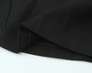 Close-up of the fine stitching and twill fabric texture on a black halter top hem
