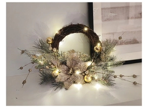 Detailed view of Christmas wreath with golden balls, faux flowers and warm LED lights
