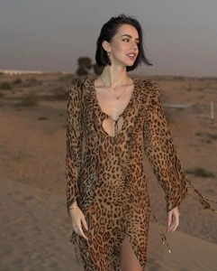 Detail of leopard print dress with ruffled neckline and tie-up long sleeves in desert light