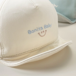 Detail of Bonita Baby embroidery and soft cotton texture on beige baby baseball cap