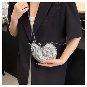 Detailed close-up of a silver snail-shaped evening clutch bag with glossy metallic texture