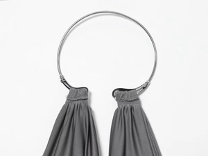 Detail of grey pleated knit dress featuring a stylish silver metal ring ornament