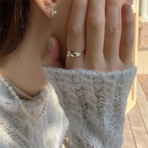Close-up of elegant 925 sterling silver twist ring and pearl necklace on a model