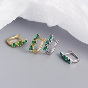 Detail of S925 silver U-shape earrings with green zircon in gold and silver finishes