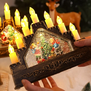 House-shaped Christmas lantern with LED candles and snow scene held in hands