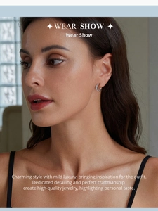 Close-up of wavy s925 sterling silver hoop earrings worn on a female model