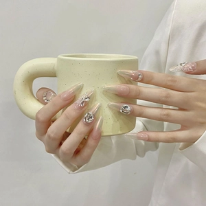 Long almond aurora press-on nails with butterfly and rhinestone details on hands