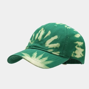 Détail d'une casquette en coton avec motifs tie-dye vert et jaune et visière pré-courbée
