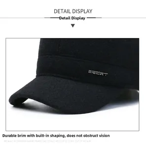 Detail of winter flat cap showing a sturdy brim and metallic SPORT logo on thick wool fabric