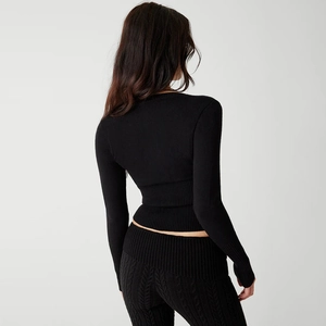 Detailed back view of a slim-fit black cable-knit cropped cardigan and matching pants