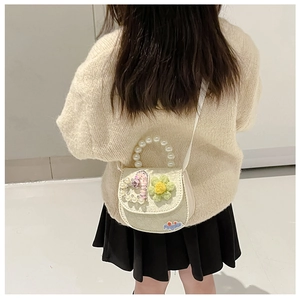 Detail of cream girls crossbody bag with pearl handle and cute floral embellishments
