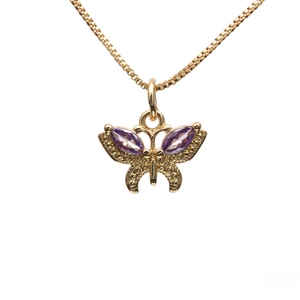 Detail of a golden butterfly pendant with purple crystals on a delicate necklace chain