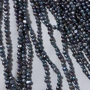 Strands of 4-5mm natural black baroque freshwater pearls with colorful metallic luster