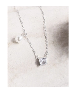 Detail showing elegant silver chain with square cut crystal and white pearl pendant