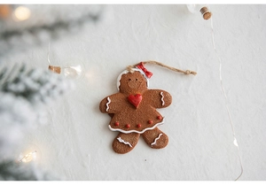 Close-up of resin gingerbread man ornament with red bow and white icing detail