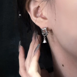 Macro shot of liquid metal butterfly earring with a clear zircon pendant on an ear